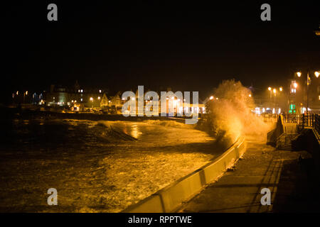 Porthcawl, South Wales, Regno Unito. 22 febbraio 2019 UK meteo: grandi onde lungo la costa gallese stasera come Supermoon continua ad avere un effetto sulle maree. Le onde testare il nuovo mare difese, con un £ 3 milioni progetto ancora in fase di lavoro, per proteggere gli edifici sul lungomare per i prossimi anni. Credito: Andrew Bartlett/Alamy Live News Foto Stock