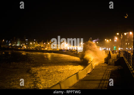 Porthcawl, South Wales, Regno Unito. 22 febbraio 2019 UK meteo: grandi onde lungo la costa gallese stasera come Supermoon continua ad avere un effetto sulle maree. Le onde testare il nuovo mare difese, con un £ 3 milioni progetto ancora in fase di lavoro, per proteggere gli edifici sul lungomare per i prossimi anni. Credito: Andrew Bartlett/Alamy Live News Foto Stock