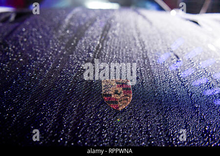 Berlino, Germania. Il 21 febbraio, 2019. Un wet-piovuto Porsche con il logo sul cofano auto si trova di fronte il freddo di Berlino store durante la presentazione di fascia alta di collezione di abbigliamento sportivo da PUMA e Porsche Design. La raccolta di materiali e tecnologie innovativi è stata qui rappresentata per la prima volta come un mercato internazionale di lancio. Credito: Jens Kalaene/dpa-Zentralbild/dpa/Alamy Live News Foto Stock