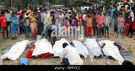 Golaghat, India. Il 22 febbraio, 2019. Gli abitanti di un villaggio di sostare di fronte i corpi delle vittime che hanno trovato la morte di bere il liquore illegale nel quartiere Golaghat, Assam, India, 22 febbraio, 2019. Il numero di decessi dovuti al consumo di liquore illegale in India del nord-est stato di Assam venerdì è salito a 41, funzionari di governo locali detto. Oltre 60 altri sono negli ospedali sottoposti a trattamento. Credito: Stringer/Xinhua/Alamy Live News Foto Stock