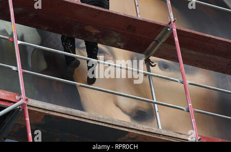 Berlino, Germania. Il 21 febbraio, 2019. Un irroratore, seduto sulla impalcatura, completa il grande murale di Monna Lisa a casa dell'East Side Hotel. Credito: Annette Riedl/dpa/Alamy Live News Foto Stock