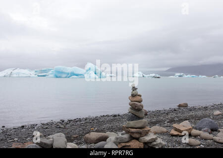 Un tumulo di pietre in corrispondenza del bordo di Jokulsarlon laguna glaciale Foto Stock