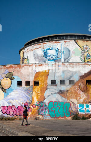 Donna oltrepassando un elaborato street arte murale a Siviglia, Spagna Foto Stock