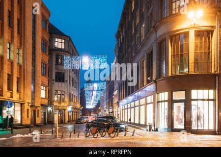 Riga, Lettonia. Fila di biciclette a noleggio a parcheggio bici su Valnu Street In illuminazione Illuminazione notturna Foto Stock