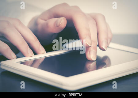Mano femmina con tavoletta digitale computer in ambienti interni Foto Stock