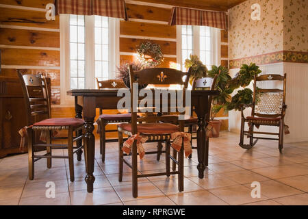 Stile antico tavolo da pranzo e sedie nella sala da pranzo di un 1978 riproduzione di un vecchio Canadiana cottage in stile log e fieldstone home Foto Stock