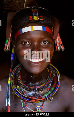 Ritratto di un sorridente Hakaona (Zemba) donna con ornamenti tradizionali e acconciatura. La Namibia, Africa Foto Stock