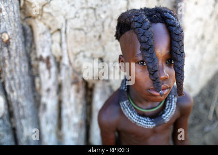 Himba ragazza con due trecce e gioielli, ritratto, Himba capanna, villaggio Himba, Namibia settentrionale Foto Stock