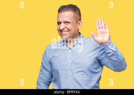 Età media arab business man su sfondo isolato rinuncia a dire ciao felice e sorridente, gentile gesto di benvenuto Foto Stock