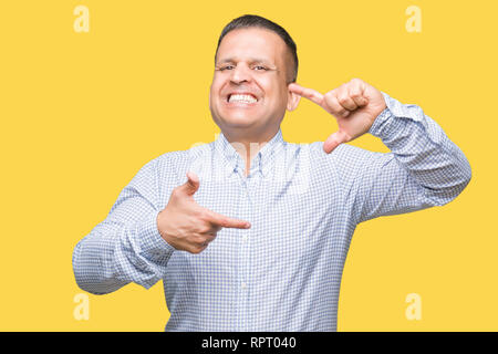 Età media arab business man over isolato sorridente sfondo rendendo il telaio con le mani e le dita con la faccia felice. La creatività e il concetto di fotografia. Foto Stock