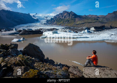 Persona accanto a Kviarjokull ghiacciaio e il Lago Moraine. Vatnajokull National Park, Sudhurland, sud est dell'Islanda. Foto Stock