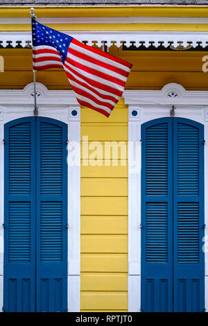 Porte anteriori, esterno di un fucile da caccia casa con porte blu e la bandiera americana, downtown New Orleans, New Orleans French Quarter, New Orleans, in Louisiana. Foto Stock