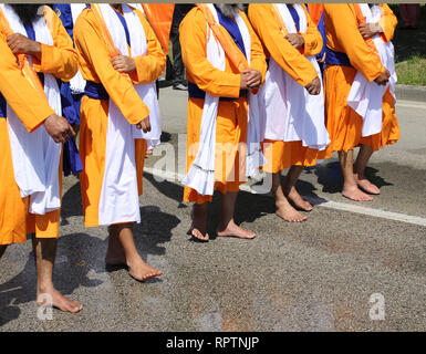 A piedi nudi uomini di religione Sikh durante una marcia su strada Foto Stock