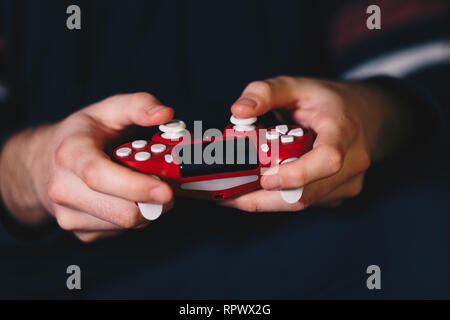 Close up dei maschi di mani di un joystick e di giocare con i videogiochi. Foto Stock