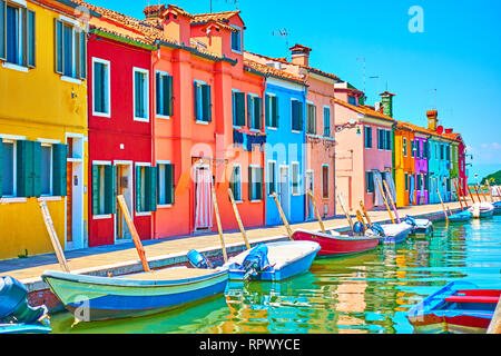 Prospettiva di canal con barche e le pittoresche case di Burano su estate giornata soleggiata, Venezia, Italia Foto Stock