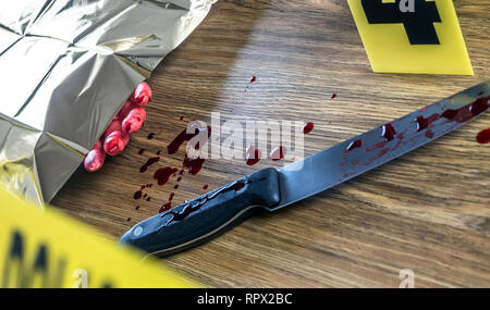 Omicidio scena per arma da taglio, sanguinolento mano lungo con un coltello con sangue, immagine concettuale Foto Stock