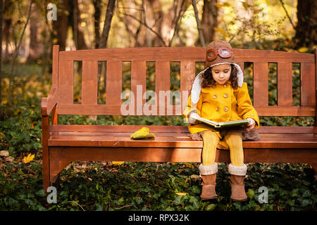 Ragazza seduta su una panchina nel parco la lettura di un libro, Bulgaria Foto Stock