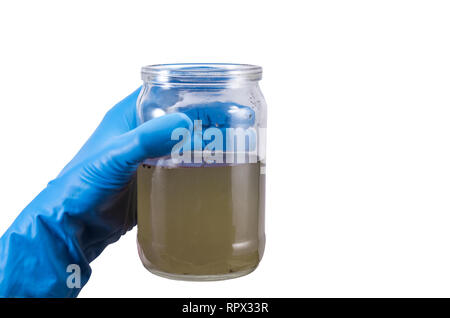 Sporco infettive contaminato acqua in un vaso in mano guanto di gomma isolati su sfondo bianco Foto Stock