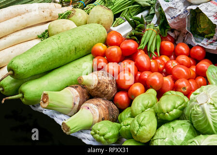 Close-up di vario genere di verde e rosso e verdure colorate visualizzate per la vendita da parte di fornitori in una strada a Chinatown, Manila, Filippine Foto Stock