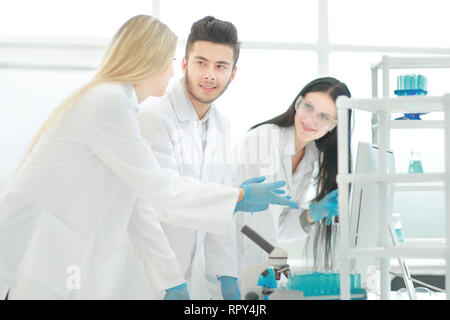 Un gruppo di giovani scienziati a discutere di qualcosa nel proprio laboratorio Foto Stock