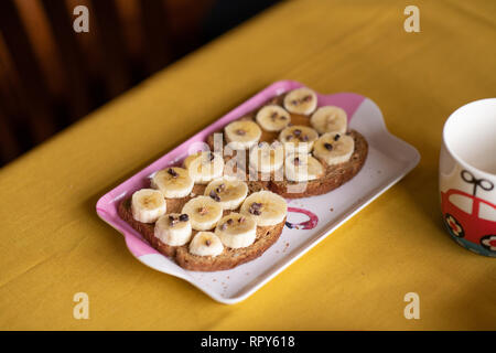 Banana, toast con burro di arachidi Cacao naselli e miele Foto Stock