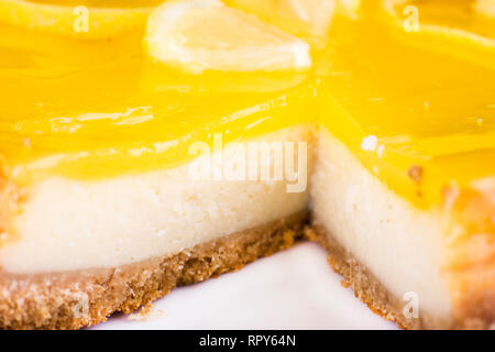 Cheesecake al limone decorata con una scorza di limone vicino. Messa a fuoco selettiva Foto Stock