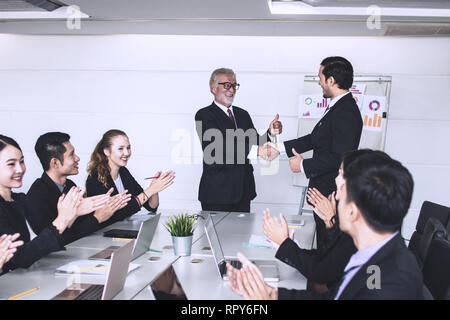 Felice e gioiosa riunione aziendale con intrattenere, agitare a mano con il lavoro di squadra Foto Stock