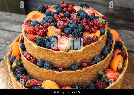 Primo piano della cheesecake con frutti e bacche sul vecchio tavoloni Foto Stock