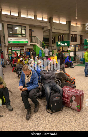 Il Nepal, Kathmandu, l'aeroporto internazionale di Tribhuvan, domestici area di partenza, i passeggeri seduti in attesa per i voli in ritardo a Lukla Foto Stock