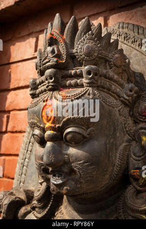 Il Nepal, Kathmandu, Swayambhunath Temple, vermillion polvere applicata a fronte tilak della divinità antica statua Foto Stock