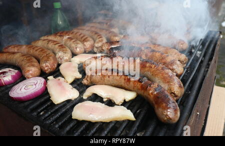 Salsicce di maiale, la pancetta e la cipolla rossa arrostito sul carbone, cucina tradizionale bulgara. Barbecue Foto Stock