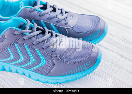 Blu e grigio sneakers su sfondo di legno. Scarpe sportive Foto Stock