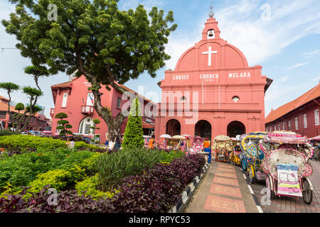 Trishaws aspettano i turisti di fronte la Chiesa di Cristo, costruito 1753, Melaka, Malaysia. Foto Stock