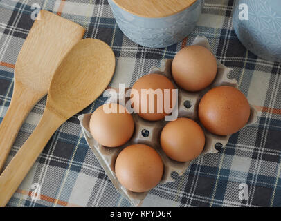 Di uova fresche in carta casella di uovo, con accessori da cucina per Pasqua pasto preparato Foto Stock