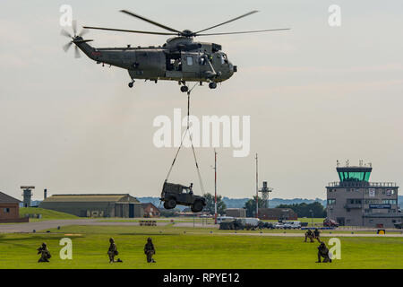 Royal Navy Westland Sea King HC4 elicottero sollevamento di un Land Rover durante il commando Assault dimostrazione a RNAS Yeovilton, UK Air giorno 26/7/14. Foto Stock