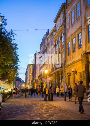 I turisti al tramonto su Rynok o Piazza del Mercato, la piazza principale della città vecchia di Lviv in Ucraina. Il suo ben conservato architettonica che si fonde Centr Foto Stock