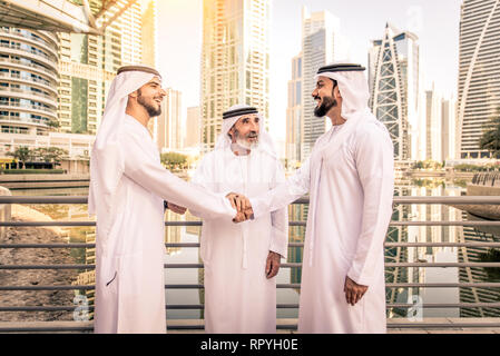 Gruppo di imprenditori arabo con kandura sale riunioni all'aperto negli EMIRATI ARABI UNITI - medio-orientali di uomini in Dubai Foto Stock