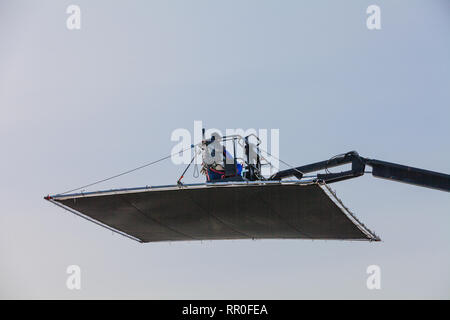 Troupe operatore che controlla la posizione e angolo di una schermata di ombra su un set cinematografico Foto Stock