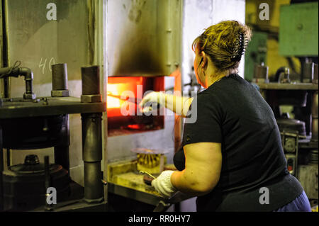 Senior donna timbri dettagli sulla pressa idraulica Foto Stock