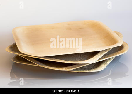 Biodegradabili eco friendly stoviglie che mostra le piastre e cucchiai realizzati da foglie di palma e legno Foto Stock