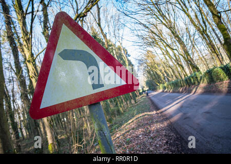 Segno per una brusca svolta a sinistra nella strada Foto Stock