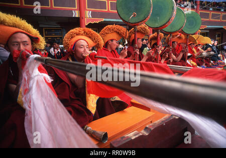 Didascalia: Kangding, Sichuan, in Cina - Maggio 2002. I monaci di soffiaggio corni cerimoniali durante la cerimonia di apertura del Sakyamuni mascherata Dance Festival in Kan Foto Stock