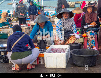 Pescherie femmina indossando cappelli conici la vendita di pesce fresco al Kedonganan Mercato del Pesce, la baia di Jimbaran Bali Indonesia. Foto Stock