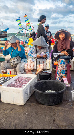 Pescherie femmina indossando cappelli conici la vendita di pesce fresco al Kedonganan Mercato del Pesce, la baia di Jimbaran Bali Indonesia. Foto Stock