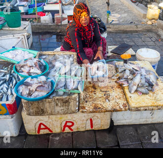 Femmina pescivendolo la vendita di pesce fresco al Kedonganan Mercato del Pesce, la baia di Jimbaran Bali Indonesia. Foto Stock