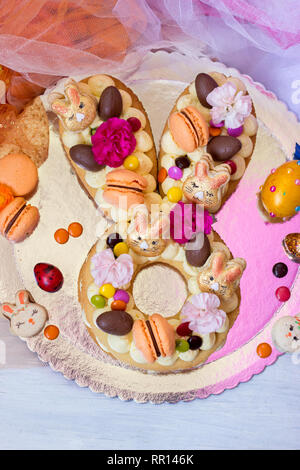 La vaniglia dolce pasquale, in Easter Bunny forma, decorato con fiori e amaretti Foto Stock