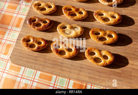 Vari biscotti sul tagliere con uno diverso dagli altri Foto Stock