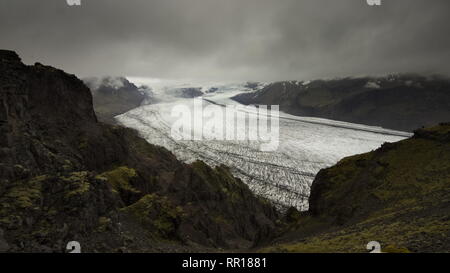 Skaftafellsjokull linguetta di ghiacciai e montagne vulcaniche intorno con cielo nuvoloso al di sopra da un sentiero escursionistico a Skaftafell National Park, Islanda. Foto Stock