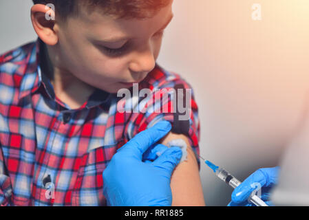 Close-up mani medico o infermiere sono la vaccinazione per paziente utilizzando la siringa iniettata la parte superiore del braccio per trattare. Medico di dare una iniezione di un paziente Foto Stock