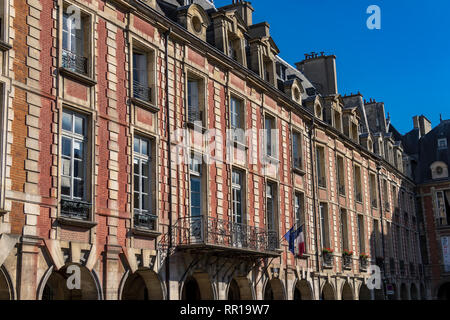 Il uniformata e armoniosa di mattoni rossi facciate di edifici che circondano Place des Vosges, la più antica piazza prevista a Parigi Le Marais, Parigi Foto Stock